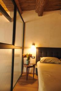 a bedroom with a bed and a table with a lamp at DADA home, Loft di 38 Mq tra Napoli e Pompei in Portici