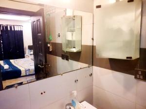 a bathroom with a mirror and a sink at The Red one bedroom apartment in Bahria Town in Rawalpindi