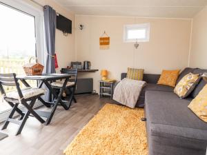 a living room with a couch and a table at The Hideaway Pod in Clitheroe