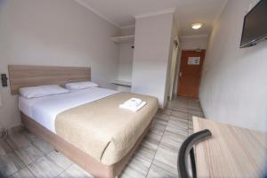 1 dormitorio con 1 cama y TV en Ecomotel Marlboro en Johannesburgo