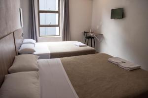 a hotel room with two beds and a window at Ecomotel Marlboro in Johannesburg