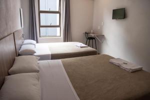 Habitación de hotel con 2 camas y ventana en Ecomotel Marlboro, en Johannesburgo