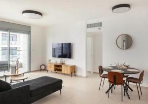 a living room with a couch and a table at O&O Group-Fresh 3BR APT 32 Floor See View Tower in Bat Yam