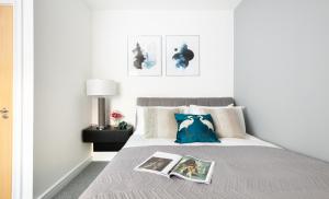 een slaapkamer met een bed met een boek erop bij Modern and Spacious 3 bed apt next to The Shard in Londen