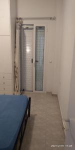 Habitación con cama y puerta con ventana en Παραθαλάσσιο Διαμέρισμα στο Ακρογιάλι3, en Akrogiali