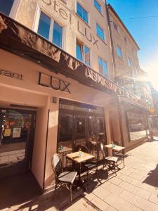 een restaurant met tafels en stoelen voor een gebouw bij Hotel Lux in München
