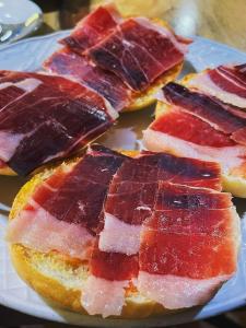 um prato de comida com bacon em Hostal Asador Julian em Brunete