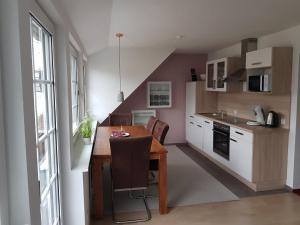 a kitchen with a wooden table and a dining room at Altastenberger Lodge in Winterberg