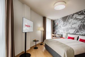 a hotel room with a bed and a poster on the wall at IntercityHotel Amsterdam Airport in Hoofddorp