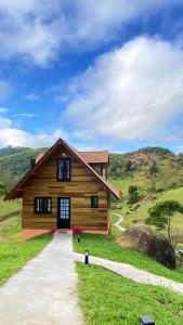 a large wooden house on a grassy hill at Sitio do Galdino in Armazém