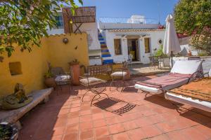 een patio met stoelen, een tafel en een parasol bij Casa Liberdade in Faro