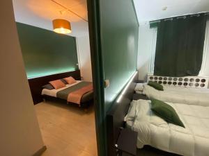a room with two beds and a bedroom with a bed sqor at Citadel Hôtel in Calais
