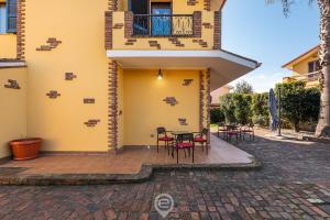 a patio outside of a house with tables and chairs at Villa Monica - Suites in Iglesias +40 photos