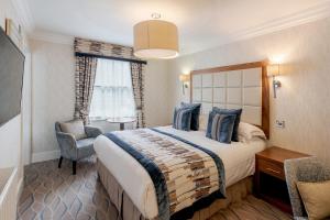 een hotelkamer met een bed en een stoel bij Skiddaw Hotel in Keswick