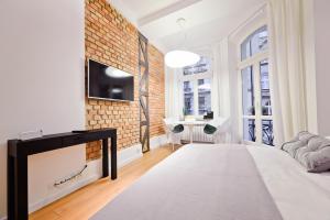 a bedroom with a fireplace and a tv on a brick wall at Apartament Centrum HGa - Garbary in Poznań