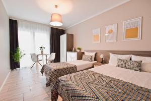 pokój hotelowy z 2 łóżkami i stołem w obiekcie Kamienica Mielno w mieście Mielno