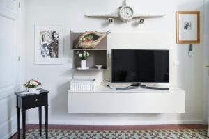 a living room with a television on a white wall at Xenia Home in Reggio Calabria