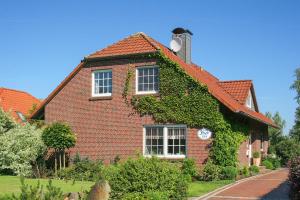 a red brick house with ivy growing on it at Ferienwohnung im Haus Solea in Esens