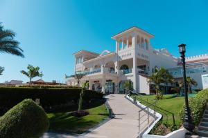 een groot wit gebouw met een pad ervoor bij Sunrise Montemare Resort -Grand Select in Sharm El Sheikh