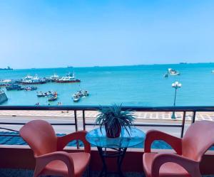 a balcony with chairs and a table and a view of the water at Lucys Hotel in Vung Tau