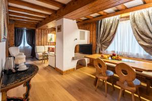 a living room with a table and chairs in a room at Parc Hotel Victoria in Cortina dʼAmpezzo