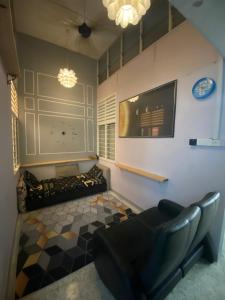 ein Wohnzimmer mit einem Sofa und einer Uhr an der Wand in der Unterkunft MARIDA HOMESTAY MusIim Only in Seremban