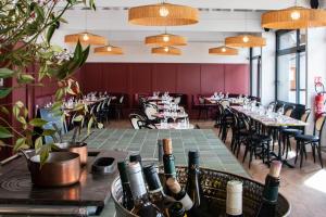 - un restaurant avec des tables, des chaises et des bouteilles de vin dans l'établissement Best Western Porte du Forez, à Andrézieux-Bouthéon