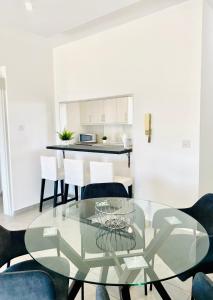 a dining room with a glass table and chairs at Lina 703 in Larnaka