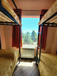 a bedroom with two bunk beds and a window at Astrolabio Hostel in San Carlos de Bariloche