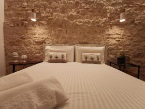 una camera con un letto bianco con due cuscini di Aracoeli 20 a Cassano delle Murge
