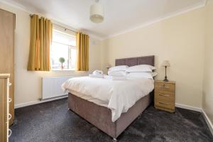 a bedroom with a large bed and a window at Cherry Tree Cottage in Thornton