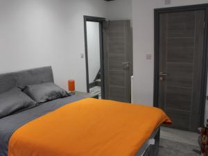 a bedroom with an orange blanket on a bed at Townhouse PLUS @ 282 Walthall Street in Crewe