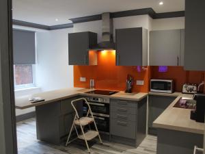 a kitchen with a stove and a chair in it at Townhouse PLUS @ 282 Walthall Street in Crewe