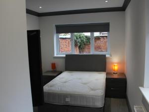 a small bedroom with a bed and a window at Townhouse PLUS @ 282 Walthall Street in Crewe +2 photos