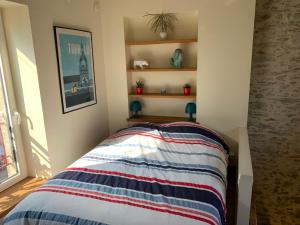 um quarto com uma cama com um cobertor listrado em Le pigeonnier de la plume em Nantes
