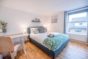 um quarto com uma cama, uma secretária e uma janela em Lily Cottage Leiston em Leiston