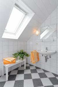 a bathroom with a sink and a mirror and a plant at Ferienwohnung im Haus Solea in Esens