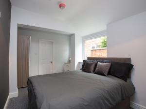 um quarto com uma cama grande e uma janela em Townhouse @ 97 Ruskin Road Crewe em Crewe