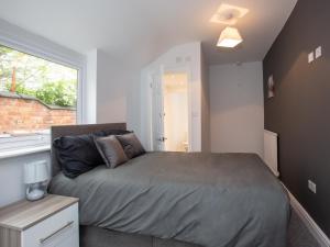 a bedroom with a large bed and a window at Townhouse @ 97 Ruskin Road Crewe in Crewe