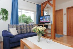 a living room with a blue couch and a tv at Ferienwohnung im Haus Solea in Esens