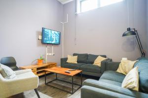 a living room with a couch and a tv at Beaverbank Place - Campus Residence in Edinburgh