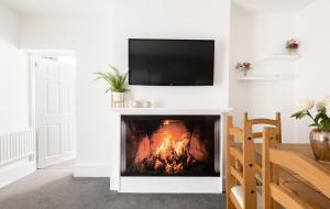 a living room with a fireplace with a tv above it at Beautiful Central 4 Bedroom Apart next2 KingsCross in London