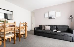 a living room with a black couch and a table at Beautiful Central 4 Bedroom Apart next2 KingsCross in London