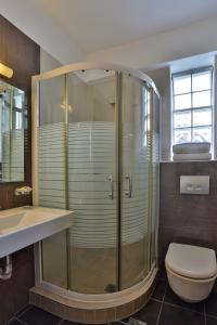 a bathroom with a shower and a toilet and a sink at Alarzo Rooms in Paralia Katerinis