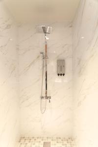 een douche in een badkamer met wit marmer bij Zhen Guesthouse in Yuanshan