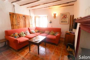 a living room with a red couch and a table at Calle Horno in Castril