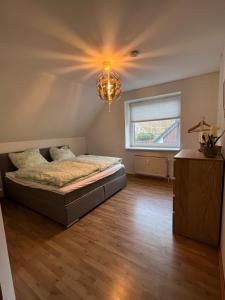 1 dormitorio con cama y lámpara de araña en Isenbüttel Ferienwohnung en Isenbüttel
