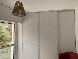 a room with white cabinets and a red chair at Appartement vue sur mer in Talmont
