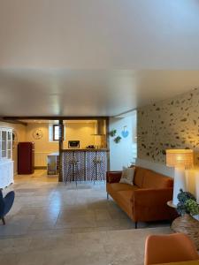 a living room with a couch and a kitchen at La Ferme de Fontenelle in Amillis