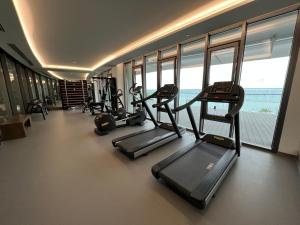 a gym with cardio equipment in a building with windows at Limassol Del Mar in Limassol
